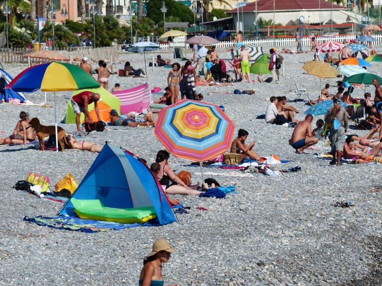 strand met mensen en parasols