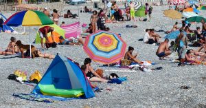 strand met mensen en parasols