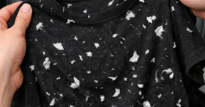 zakdoek pluisjes op zwart shirt